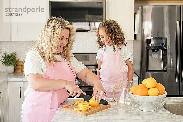 Mother showing daughter how to cut a lemon