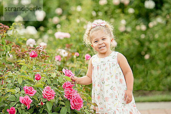 Little girl in garden with roses