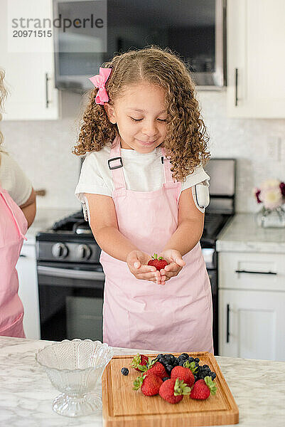 Little girl with diabetes holding a strawberry and fruit