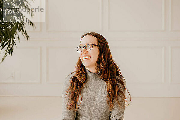 Smiling young Hispanic woman in gray sweater  clean indoor setting