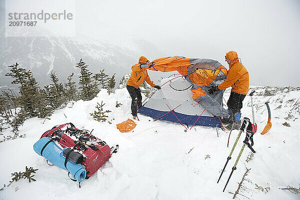 Two men set up camp in the deep snow on Mt. Washington.