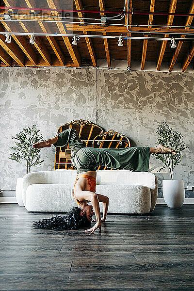 Woman performing a headstand in an artistic  indoor setting