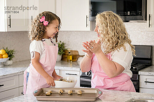 Mother and daughter laughing together while making cookies