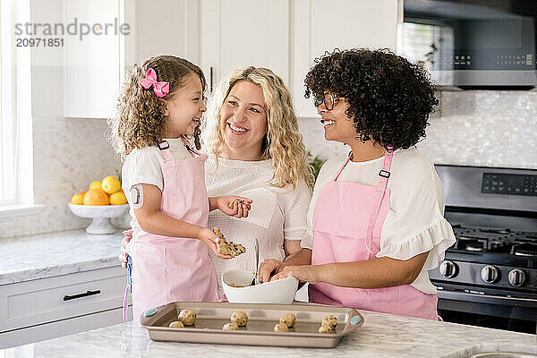 Mother and daughters laughing with each other in the kitchen