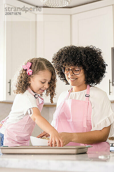 Close up of biracial sisters in the kitchen smiling