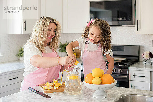 Mother and daughter making lemonade in the kitchen together