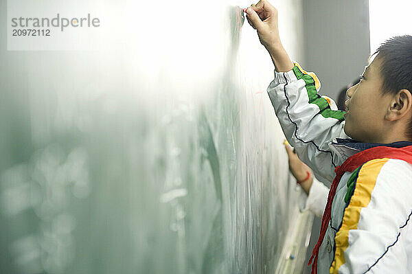 Young students practicing math on a chalkboard.