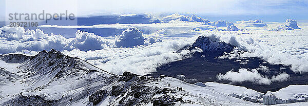 Climbers ascending the crater rim of Mt. Kilimanjaro  up from Stella Point  with Mawenzie Peak  and Rebmann Glacier seen.