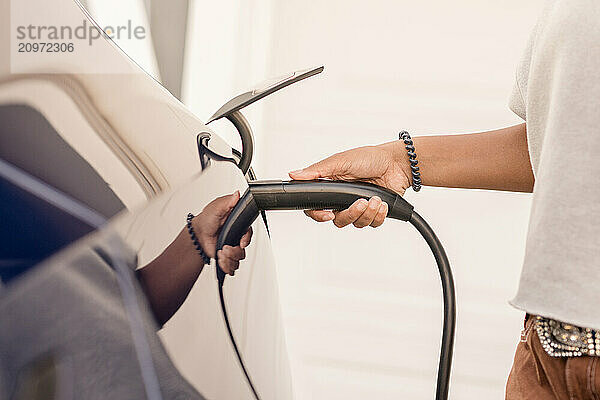 Close up of lady plugging in charger to an ev car