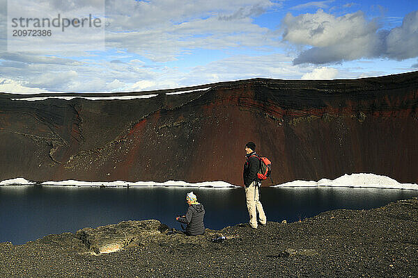 Two tourists visiting Ljotipollur volcanic crater  Iceland