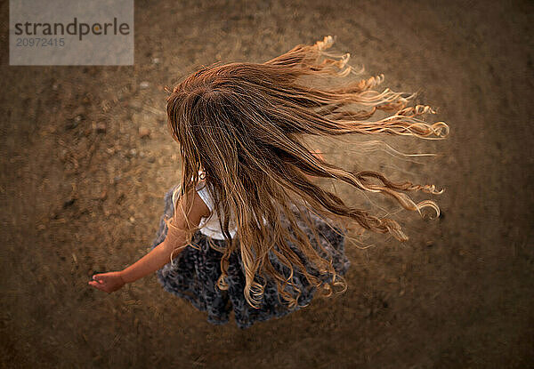 Top view young girl twirling with long blonde curls