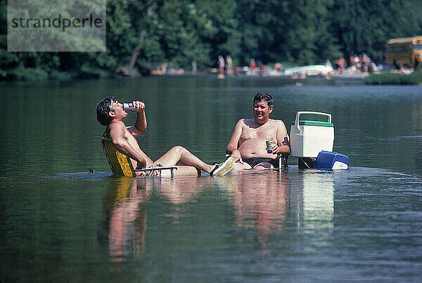 Two men relaxing in a river.