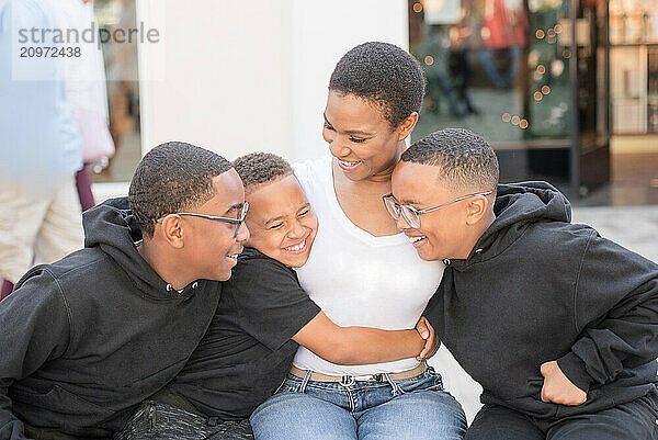 Sons hugging mother tight in downtown