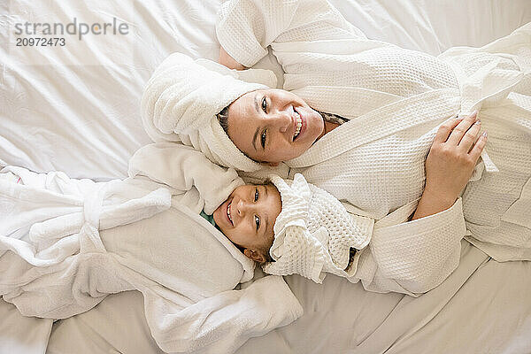 Mother and little daughter laying on their backs smiling