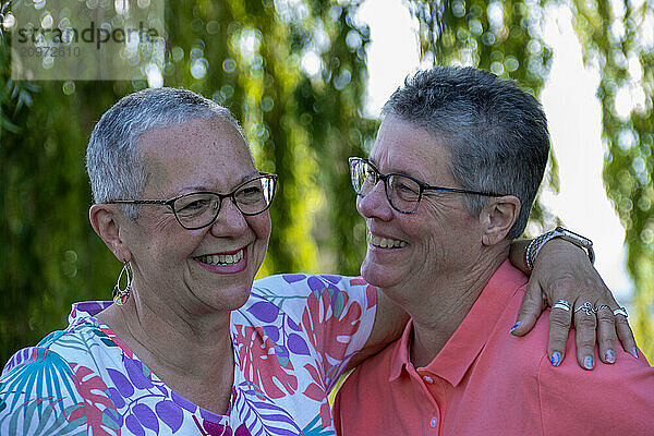 Happy older gay couple smiling and embracing outdoors