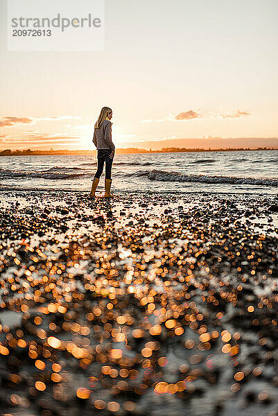 Person standing on peaceful New Zealand beach