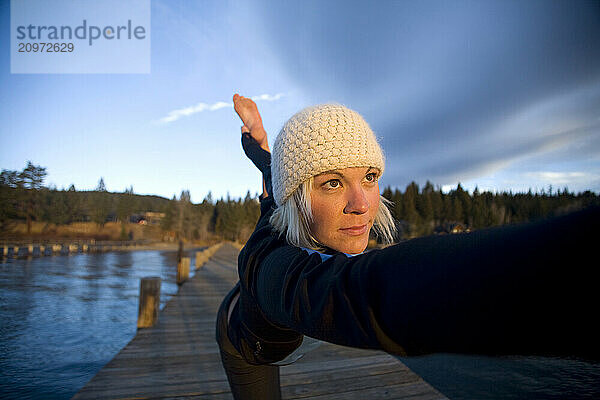 Young woman doing yoga on pier in Tahoe City  CA.