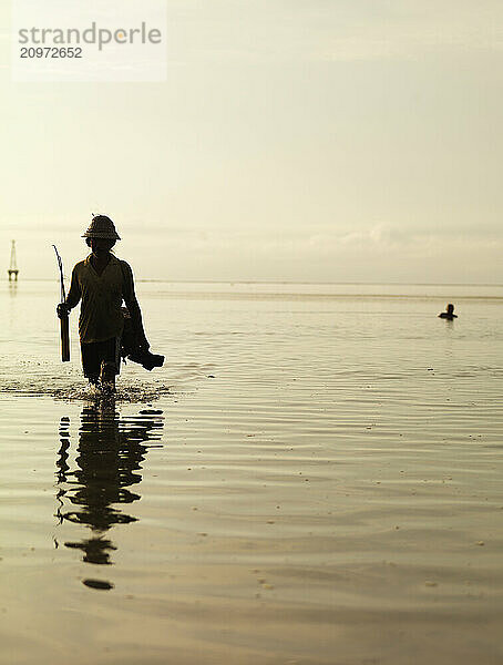 An elderly fisherman at sunset in Bali  Indonesia.