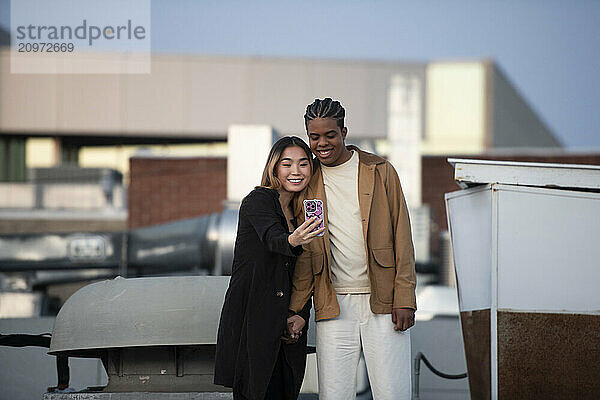 Asian woman and black african american man take selfie on a down