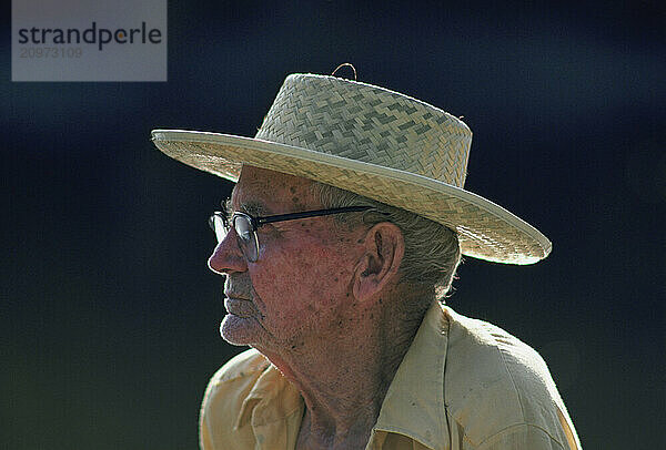 An elderly man with a straw hat.