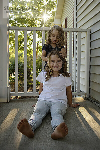 Beautiful young sisters playing outdoors sunny evening