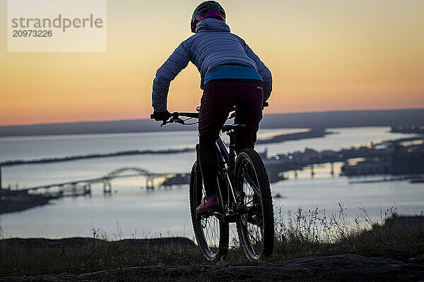 Person riding bicycle at dawn  Duluth  Minnesota  USA