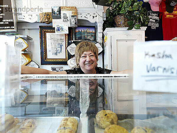 A smiling woman  working behind the counter