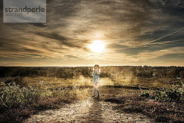 Little girl pigtails playing in dirt and dust outdoors