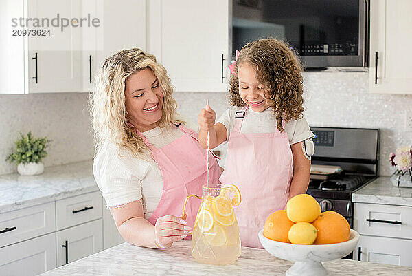 Mother and daughter with diabetes making lemonade in the kitchen