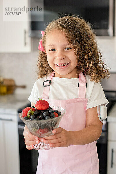 Biracial little girl with diabetes holding a bowl of fruit