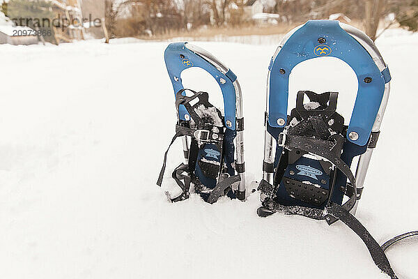 Snowshoes sticking out of snow bank