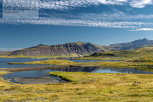 Tranquil Icelandic landscape with mountains  lakes  village