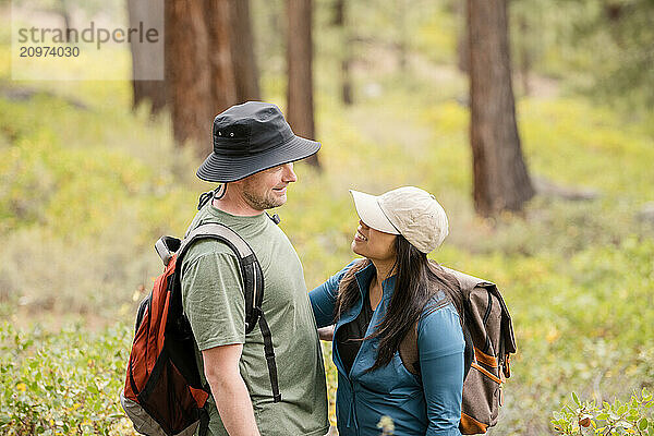 Hiker couple looking at each other in the forest