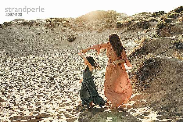 Mother daughter dancing beach summer sunset sand dunes