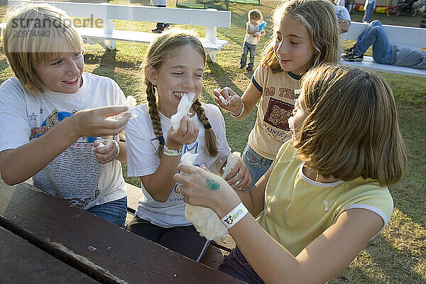 Girls enjoying maple sugar cotton candy at the Fryeburg Fair in Maine.