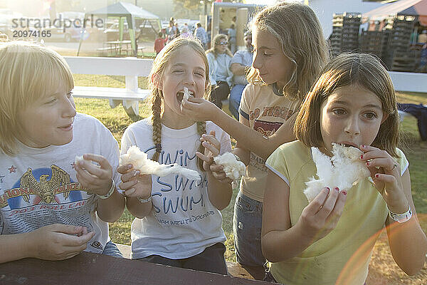 Girls enjoying maple sugar cotton candy at the Fryeburg Fair in Maine.