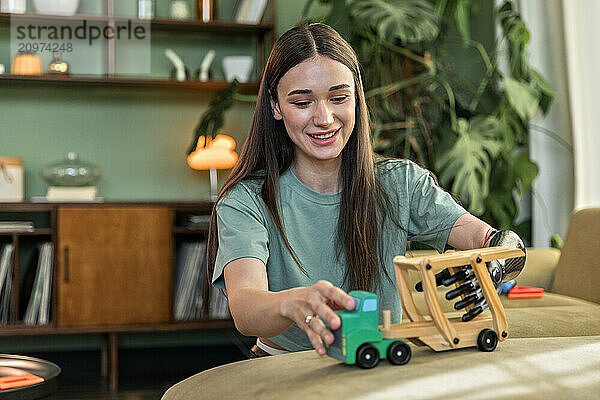 Young woman with prosthesis enjoys playing with baby toys