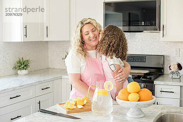 Little daughter with diabetes giving mother a kiss in the kitchen