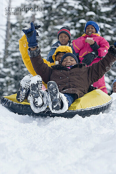 Three young kids riding snowtube at Kirkwood ski resort near Lake Tahoe  California.