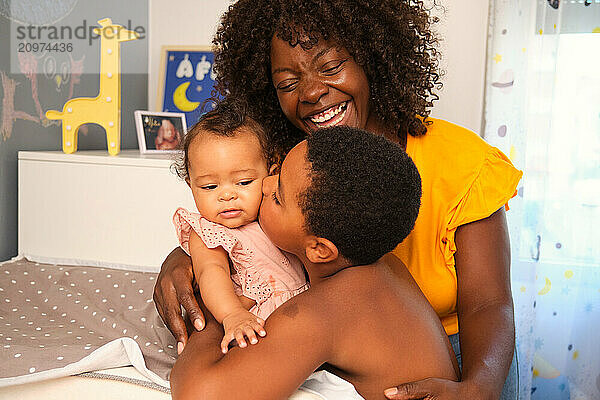 Happy family sharing tender moment in the nursery