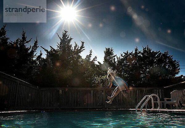 Young girl jumping into outdoors swimming poor sunny day