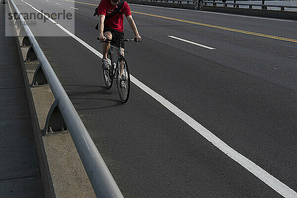 Cyclist riding along bridge on Charles River  Boston  Massachusetts  USA