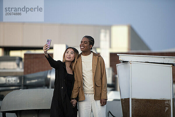 Multi racial asian and black african american take selfie on roo