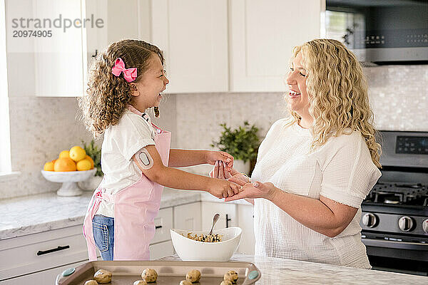 Mother and daughter holding hands laughing together