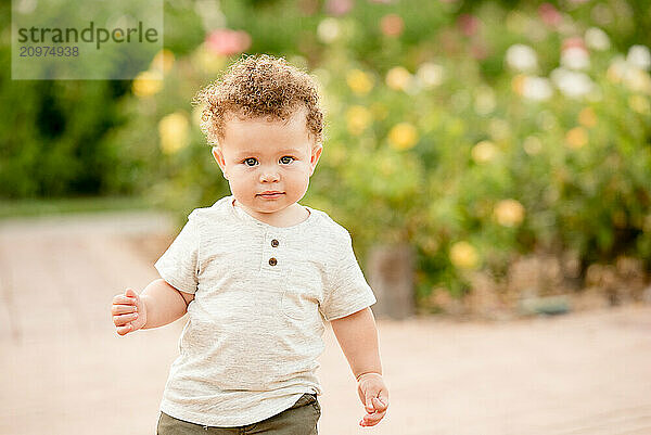 Baby boy looking at the camera in garden