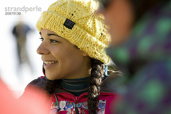 Girls in ski clothes socialize outdoors on a sunny day on the mountain.