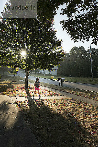 Young girl on skateboard sunny fall day