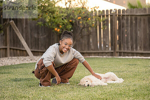 Young lady petting a young puppy