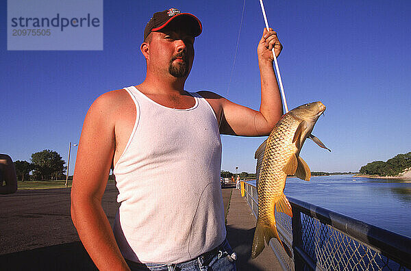 A man with a speared carp.