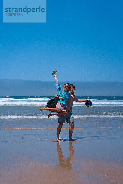 Happy friends hugging on the beach.